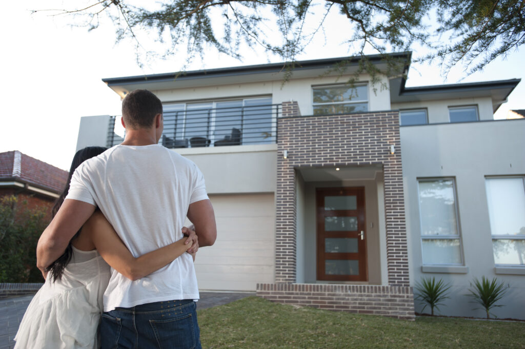 couple admiring a new house.