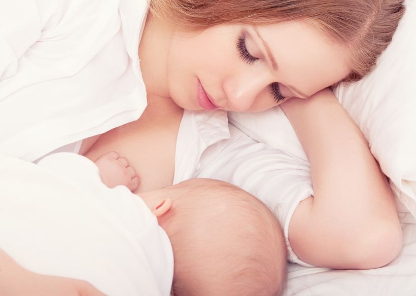 17747481 mother feeding breast her baby in the bed. sleeping together